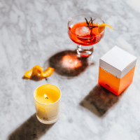 ECOYA mini candle on table with a glass of alcohol