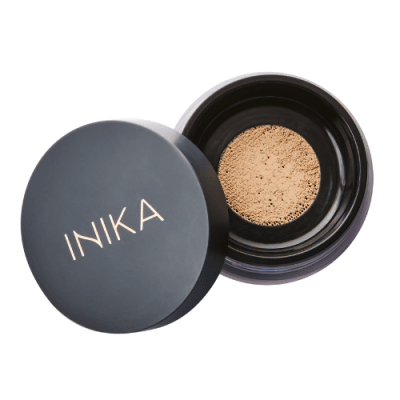 INIKA loose mineral foundation powder. Open black small jar with lid off. Mineral powder in beige in colour