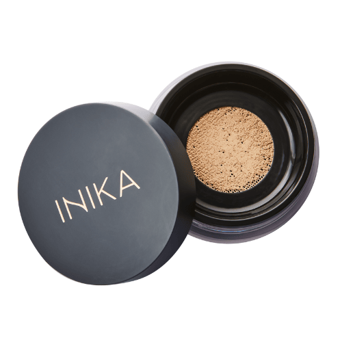 INIKA loose mineral foundation powder. Open black small jar with lid off. Mineral powder in beige in colour