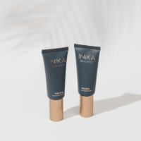 INIKA Organic primer group image. Two black tubes with gold lid