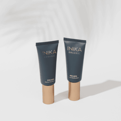 INIKA Organic primer group image. Two black tubes with gold lid