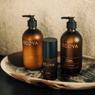 ECOYA body wash, body lotion and body oil on a tray. Orange and Saffron scent